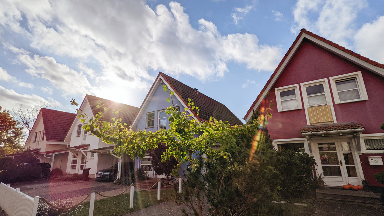 4 houses in the suburbs with the sun beaming over them